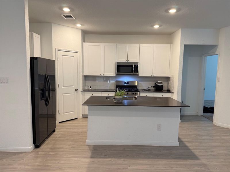 A well-appointed kitchen showcases sleek appliances and a spacious island, perfect for culinary endeavors.