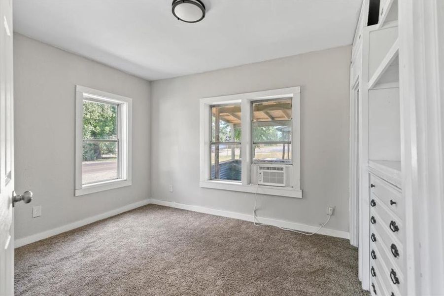 Carpeted empty room featuring cooling unit Carpeted empty room featuring cooling unit