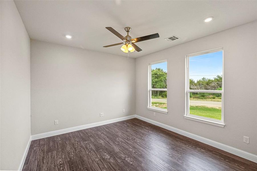 Spare room featuring dark hardwood / wood-style floors and ceiling fan