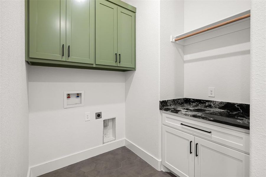 Laundry area featuring hookup for an electric dryer, cabinets, dark tile patterned floors, and washer hookup