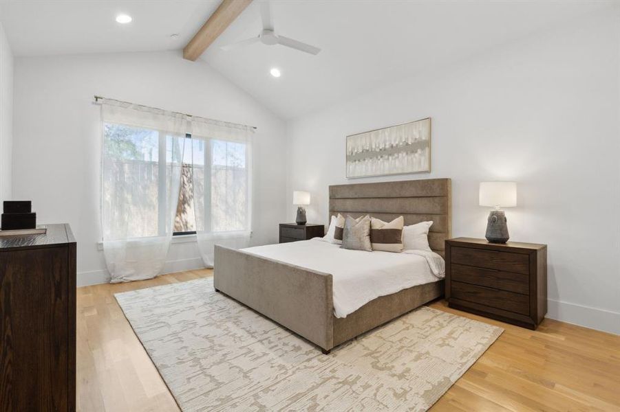 Primary Bedroom featuring vaulted ceiling with beams, light hardwood