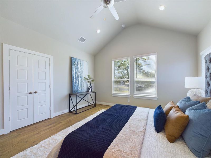 Primary bedroom has a vaulted ceiling