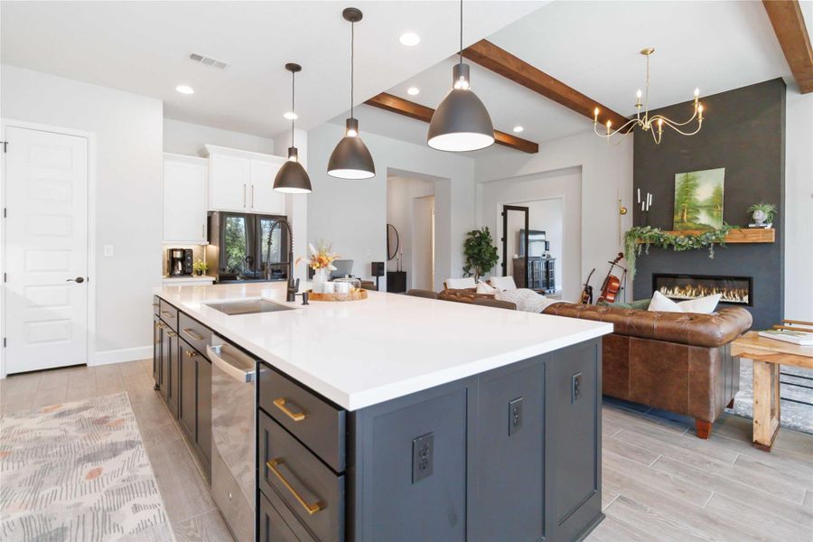 Kitchen with beamed ceiling, decorative light fixtures, wood tiled floors, a fireplace, and white cabinetry Kitchen with beamed ceiling, decorative light fixtures, wood tiled floors, a fireplace, and white cabinetry