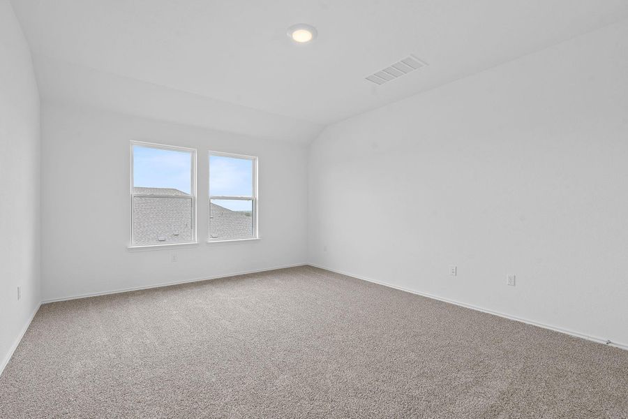 Empty room featuring carpet and vaulted ceiling Empty room featuring carpet and vaulted ceiling