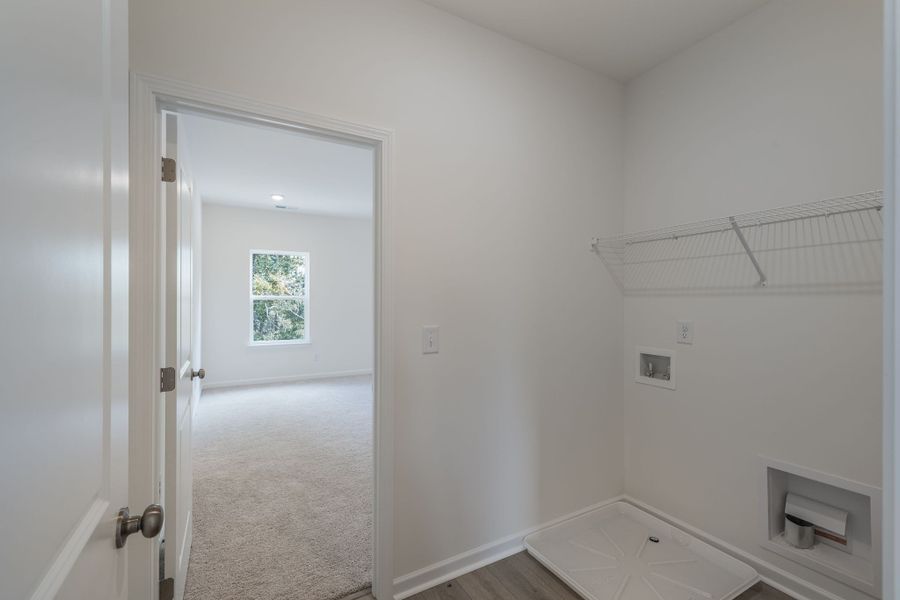 Laundry room with access to the primary bedroom.