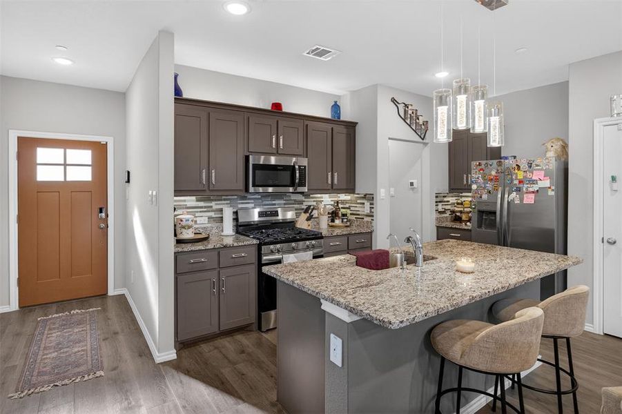 KITCHEN WITH A BREAKFAST ISLAND AND GRANITE COUNTERTOPS
