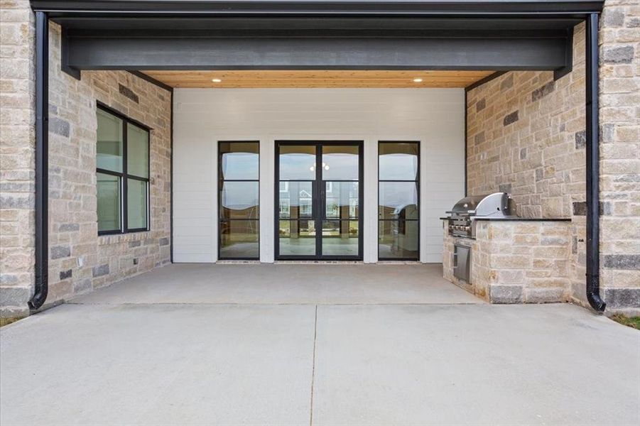 Entrance to property featuring exterior kitchen and a patio area