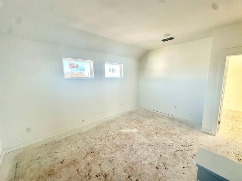 Spare room featuring vaulted ceiling