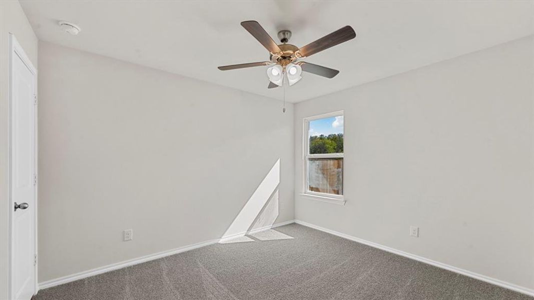 Spacious room featuring gray carpeting, white baseboards, and neutral wall paint Spacious room featuring gray carpeting, white baseboards, and neutral wall paint