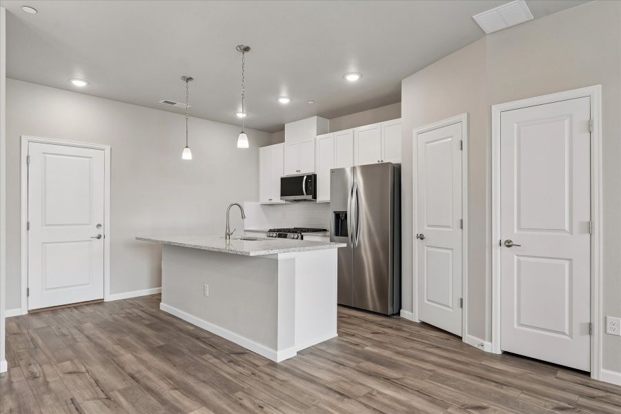 A kitchen with white cabinets.