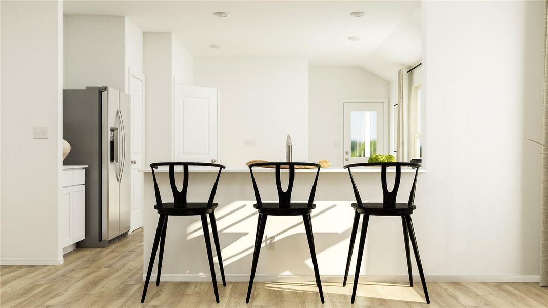 Dining area featuring light wood-style flooring and vaulted ceiling Dining area featuring light wood-style flooring and vaulted ceiling
