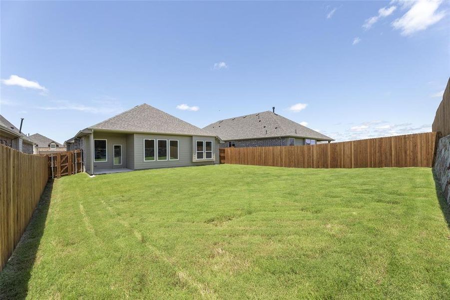 Rear view of property with a lawn