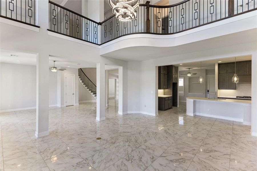 Marble-look flooring and a grand open-concept design define this striking two-story living area.