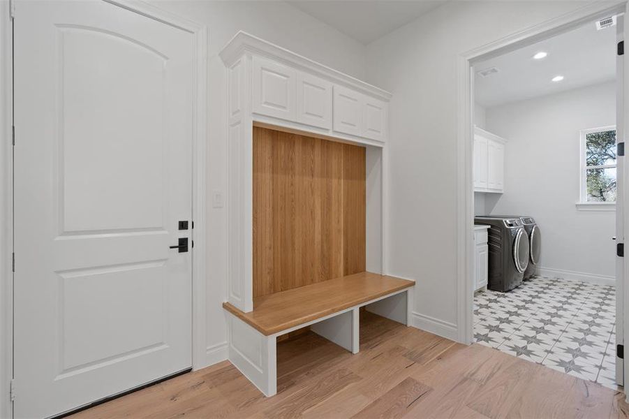 Mudroom with light hardwood / wood-style flooring and washing machine and clothes dryer