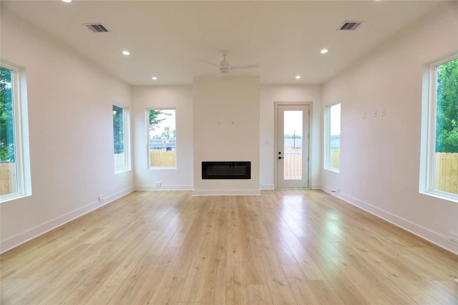 The four windows keep the living room bright and airy, while the fireplace adds a touch of warmth, creating a cozy and inviting atmosphere. The four windows keep the living room bright and airy, while the fireplace adds a touch of warmth, creating a cozy and inviting atmosphere.