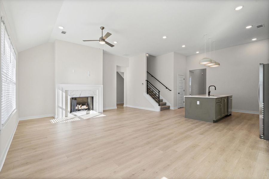 Unfurnished living room featuring a fireplace, stairs, light wood finished floors, recessed lighting, and ceiling fan Unfurnished living room featuring a fireplace, stairs, light wood finished floors, recessed lighting, and ceiling fan