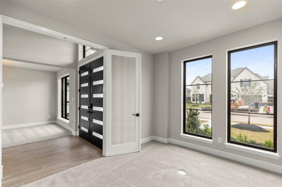 Showcases a Well-lit Home Office/Study with French Doors