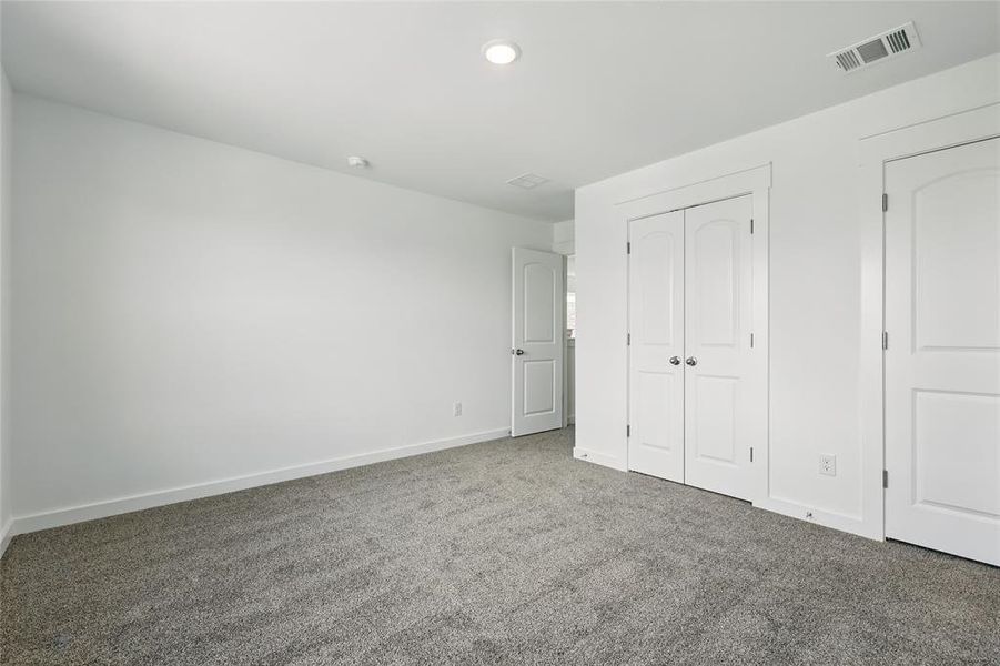 Unfurnished bedroom featuring carpet and a closet