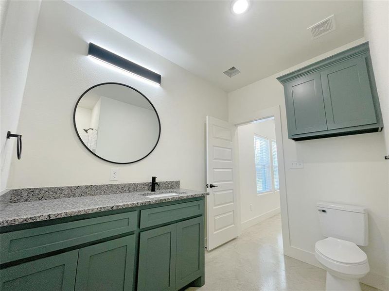 Bathroom featuring vanity, toilet, and concrete floors