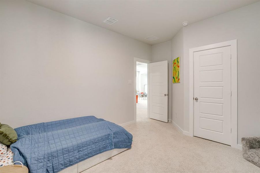 Bedroom featuring light carpet and baseboards Bedroom featuring light carpet and baseboards