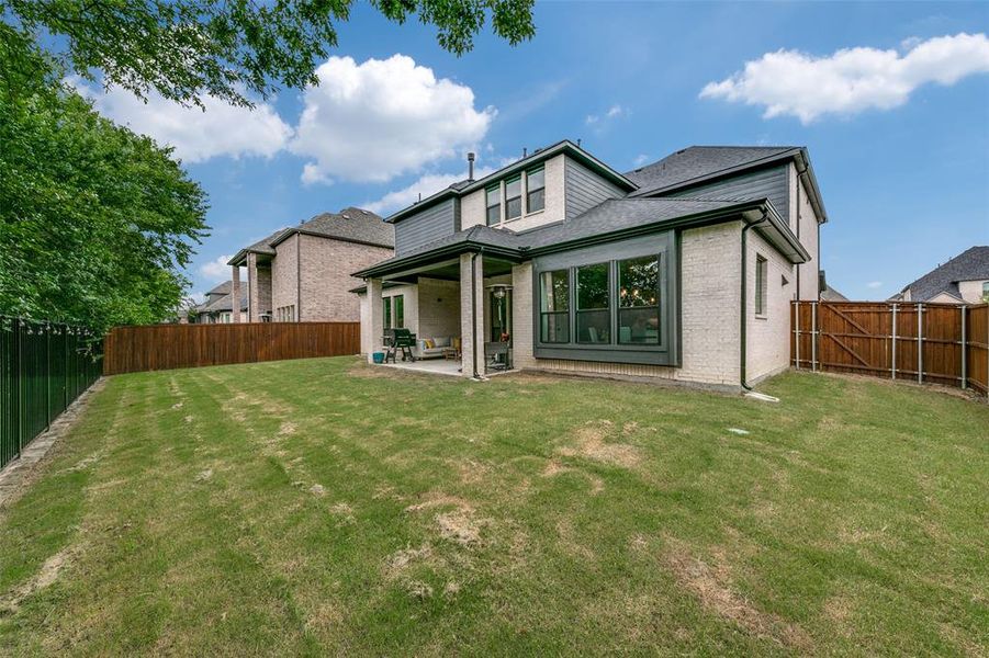 Back of property featuring a lawn and a patio