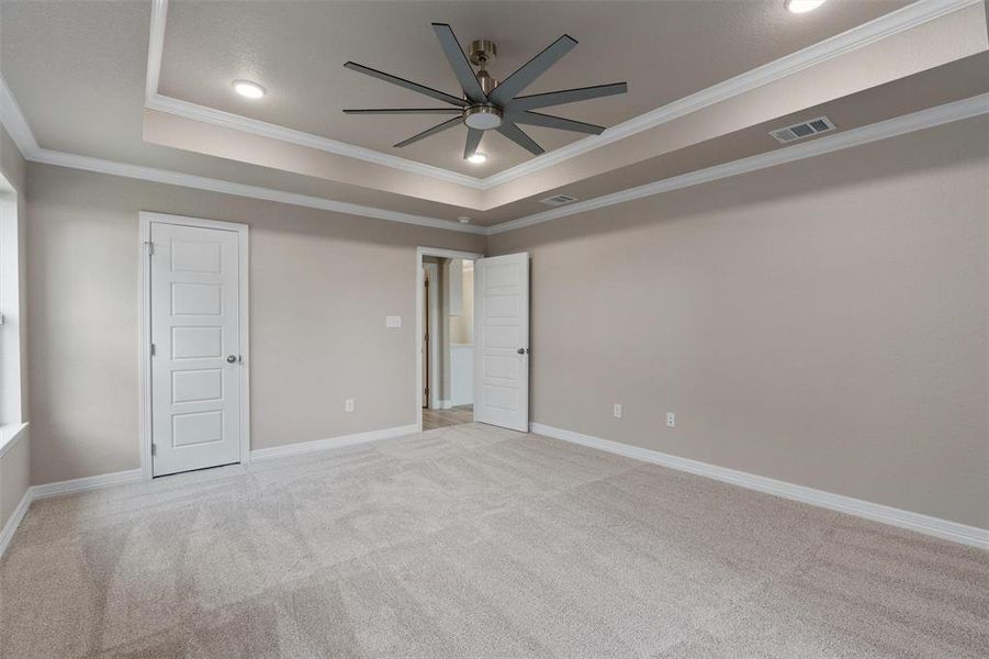 Spacious room featuring a tray ceiling with recessed lighting and a ceiling fan Spacious room featuring a tray ceiling with recessed lighting and a ceiling fan