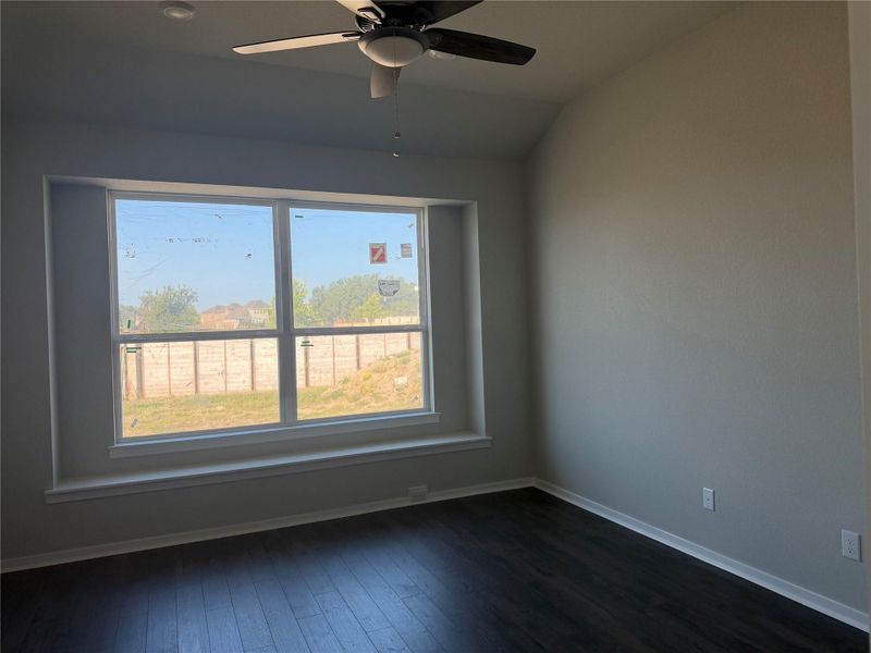 Dark wood flooring and a deep window seat frame views of the backyard.