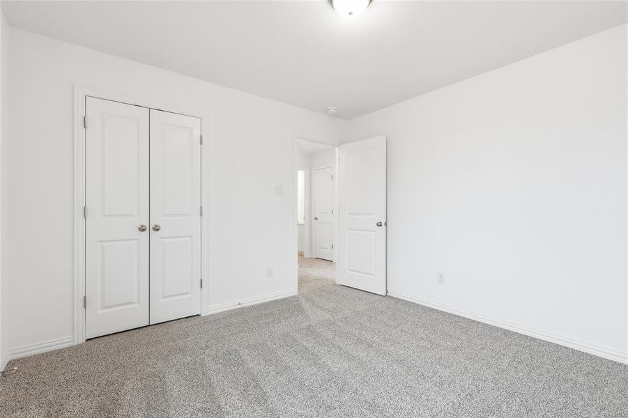 Unfurnished bedroom featuring carpet flooring and a closet