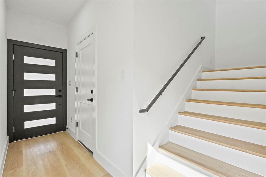Foyer featuring light wood-style flooring and stairway