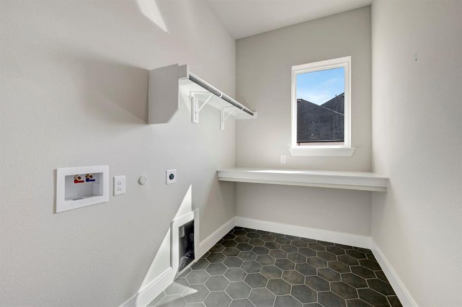 Laundry room featuring hookup for a gas dryer, hookup for a washing machine, dark tile patterned flooring, and hookup for an electric dryer Laundry room featuring hookup for a gas dryer, hookup for a washing machine, dark tile patterned flooring, and hookup for an electric dryer