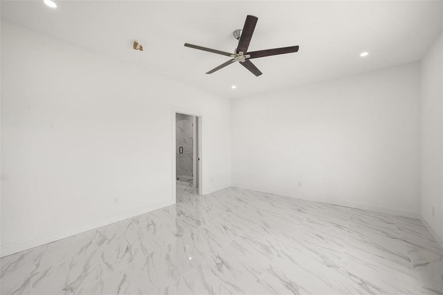 Unfurnished room with a ceiling fan, recessed lighting, and light marble finish flooring Unfurnished room with a ceiling fan, recessed lighting, and light marble finish flooring