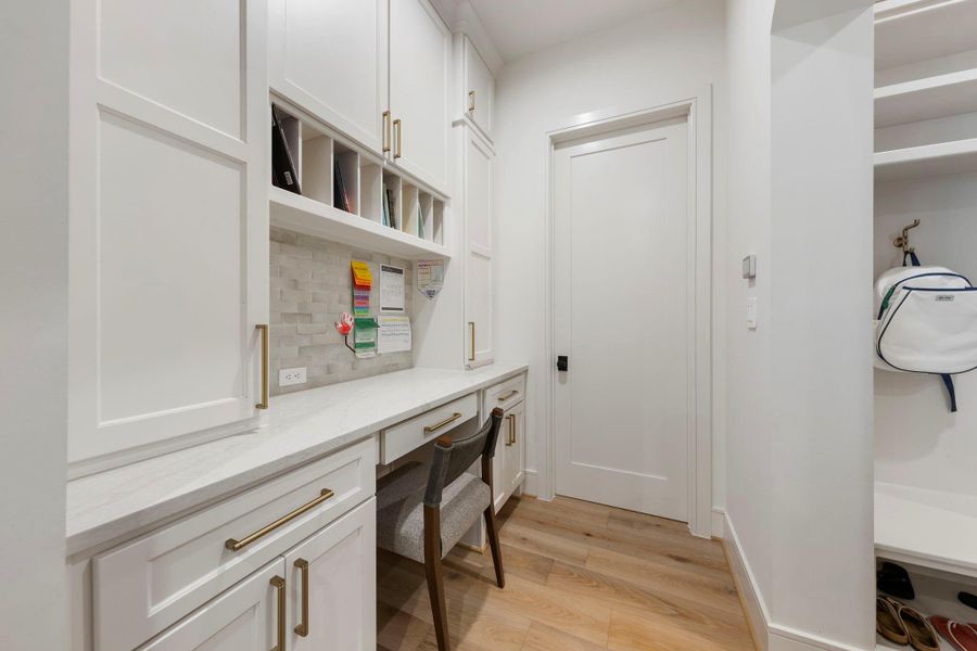 Custom built-in workstation with marble countertops, abundant cabinetry, open shelving for organization, and a tucked-away desk area—perfect for a home office, homework station, or daily planning space.