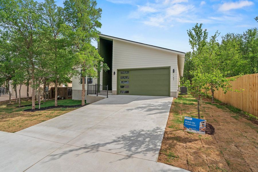 View of front of home with concrete driveway and an attached garage