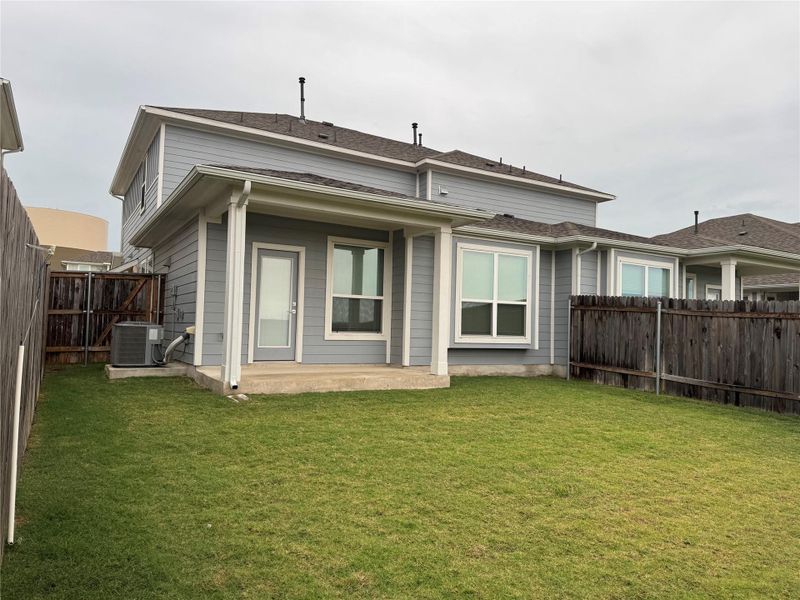 Rear view of property featuring a fenced backyard and a patio