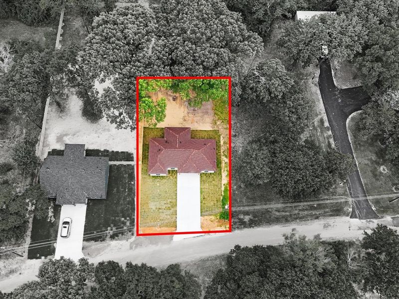 Single-story residence with a red-shingle roof, white driveway, and perimeter landscaping Single-story residence with a red-shingle roof, white driveway, and perimeter landscaping