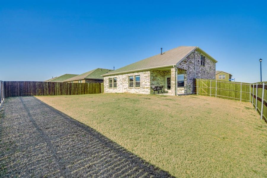 Rear view of property with a patio area, a fenced backyard, and brick siding