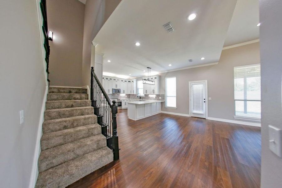 Entrance foyer with recessed lighting, stairway, dark wood-style flooring, and crown molding Entrance foyer with recessed lighting, stairway, dark wood-style flooring, and crown molding