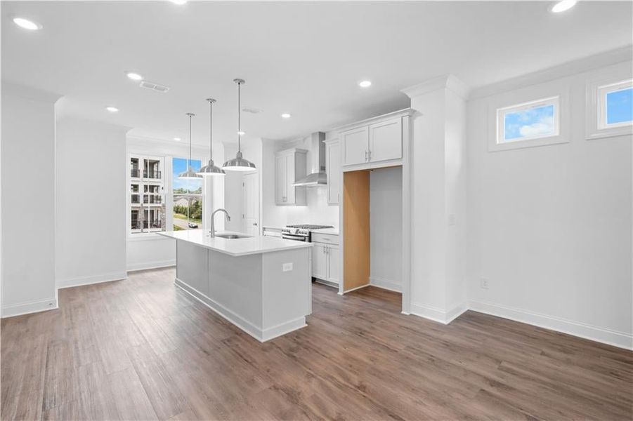 Kitchen featuring White cabinetry, pendant lighting, dark wood-style flooring, an island with sink, and recessed lighting ** Pic of previously built home for reference only, not actual home **