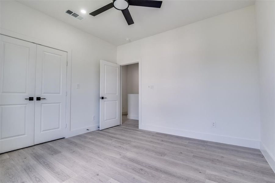 Unfurnished bedroom with light wood-type flooring, a closet, and ceiling fan Unfurnished bedroom with light wood-type flooring, a closet, and ceiling fan