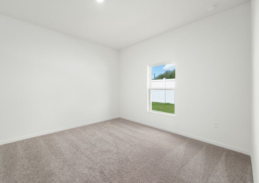 Spacious master bedroom with a window at the center of the back wall