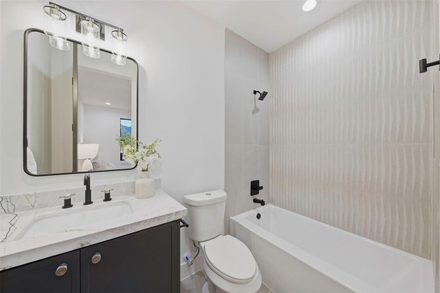 Ensuite secondary bathroom is finished with designer selections and custom cabinetry.