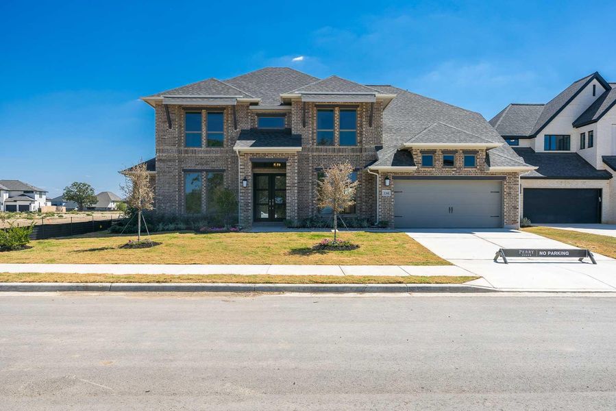 View of front of home with brick siding, a front lawn, a shingled roof, and concrete driveway View of front of home with brick siding, a front lawn, a shingled roof, and concrete driveway