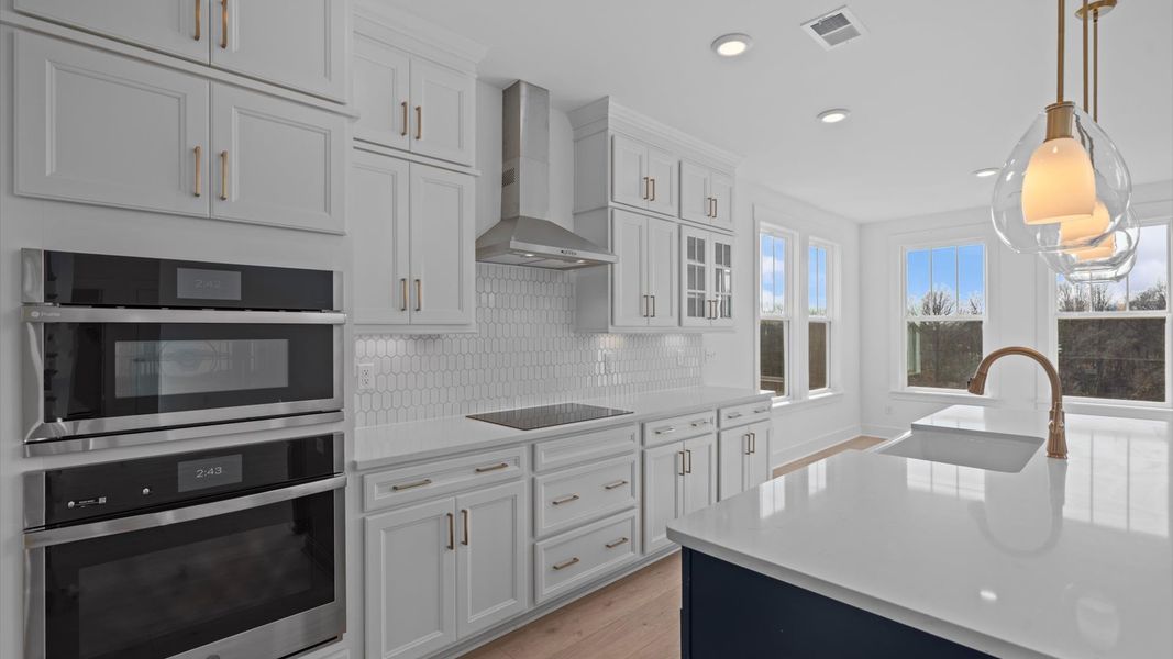 Exclusive DRB Homes kitchen with a 9-foot island, elevated finishes, and pendant lighting in a prime location