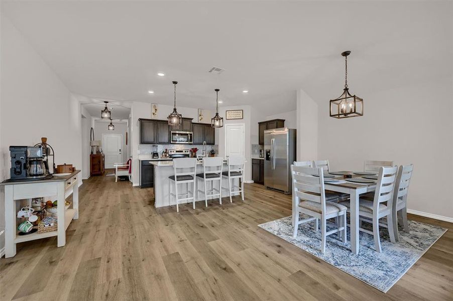 Dining area with visible vents, a chandelier, baseboards, recessed lighting, and light wood-style floors
