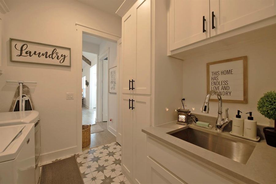 Washroom with washer and clothes dryer and cabinet space