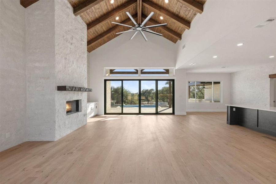 An inviting great room with vaulted beamed ceilings and a warm fireplace opens to outdoor living with sliding glass doors. An inviting great room with vaulted beamed ceilings and a warm fireplace opens to outdoor living with sliding glass doors.