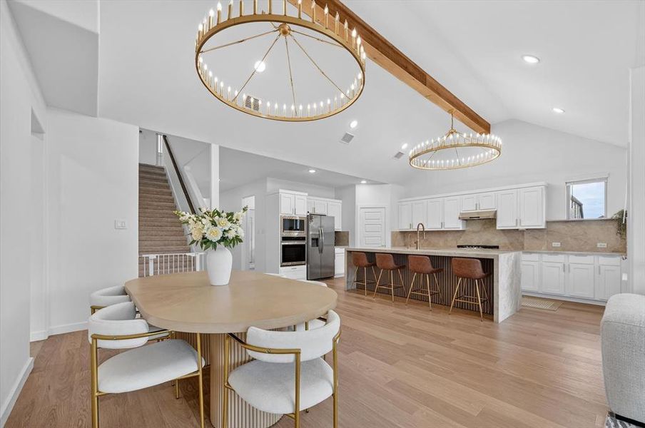 Open-concept living space featuring wood-finish flooring, vaulted ceilings, and recessed lighting