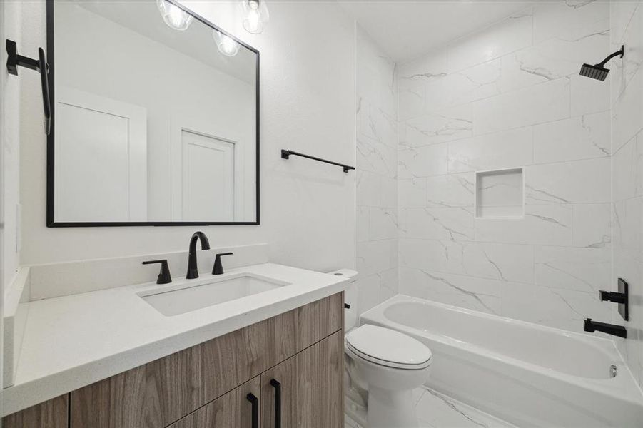 The 3rd Floor ensuite secondary bathroom features European cabinetry, quartz countertops, elegant hardware, and shower/bath combination!