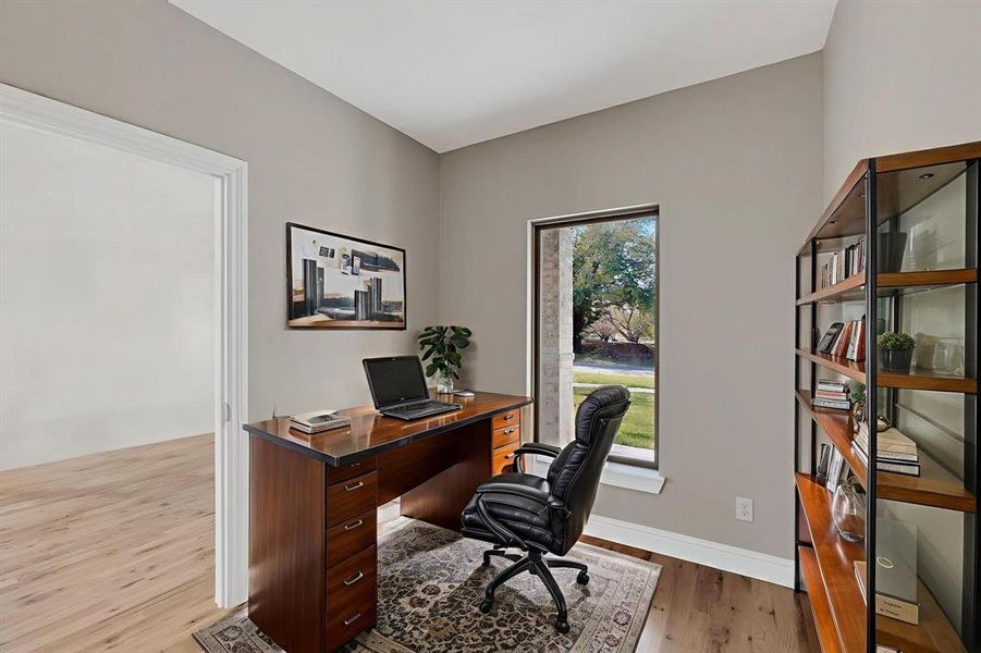 Office area featuring light wood-style flooring and baseboards