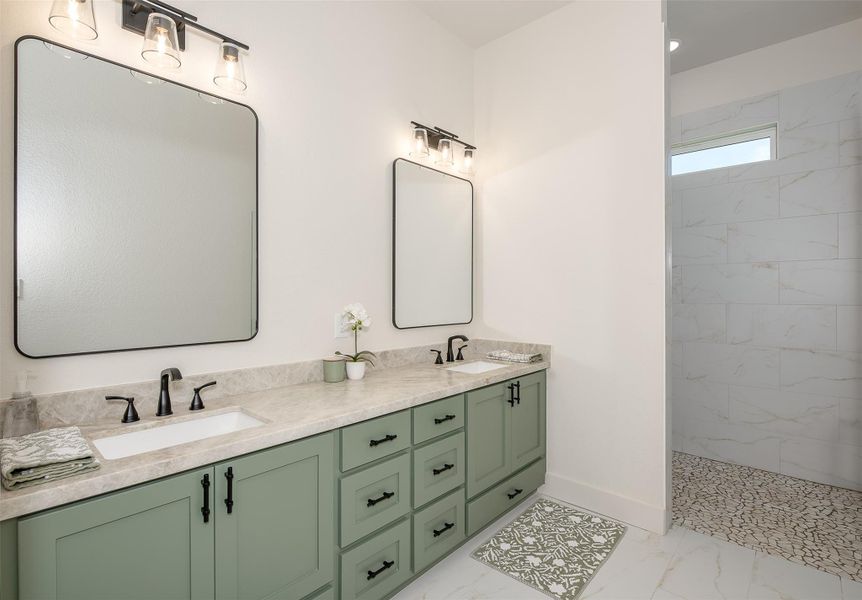 Full bathroom featuring light marble finish flooring, double vanity, and a marble finish shower